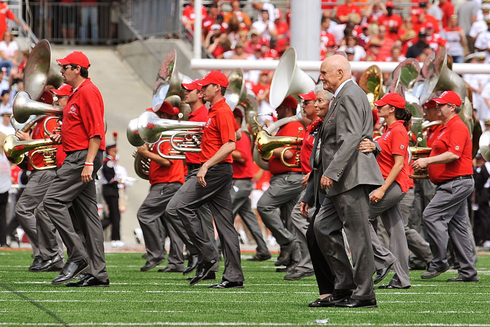 COLUMBUS, OH - SEPTEMBER 05: Former U.S. Senator John Glenn (D-OH) and his wife Annie Glenn walk off the field after dotting the ‘i’ as the Ohio State Alumni Marching Band forms script Ohio during halftime of a game against the Navy Midshipmen at Ohio Stadium on September 5, 2009 in Columbus, Ohio. (Photo by Jamie Sabau/Getty Images)