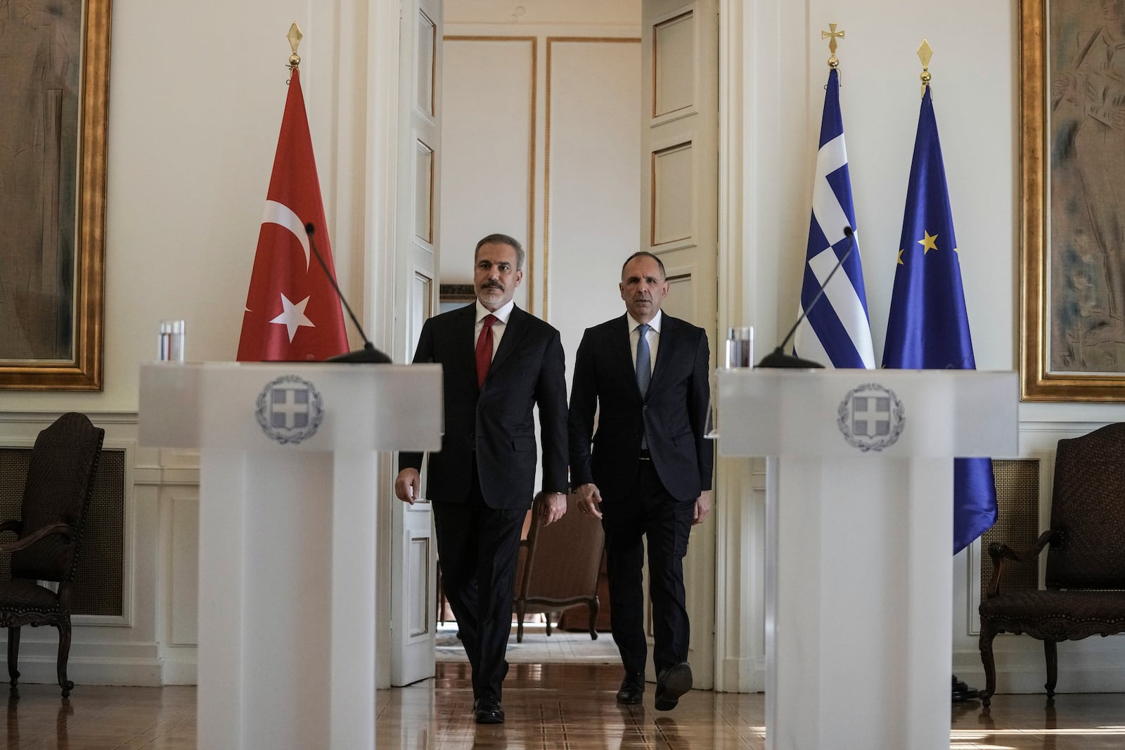 Greek Foreign Minister George Gerapetritis, right, and his Turkish counterpart Hakan Fidan arrive for a join news conference and after their meeting, in Athens, Greece, Friday, Nov. 8, 2024. (AP Photo/Thanassis Stavrakis)