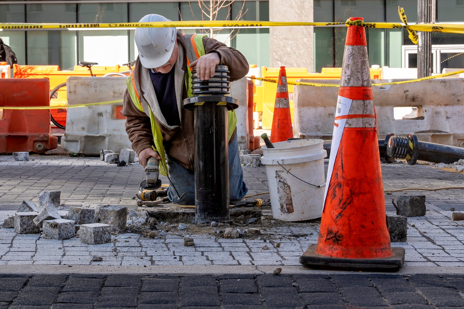 A worker leans on a traffic bollard during demolition of the Black Lives Matter mural, Monday, March 10, 2025, in Washington. (AP Photo/Jacquelyn Martin)