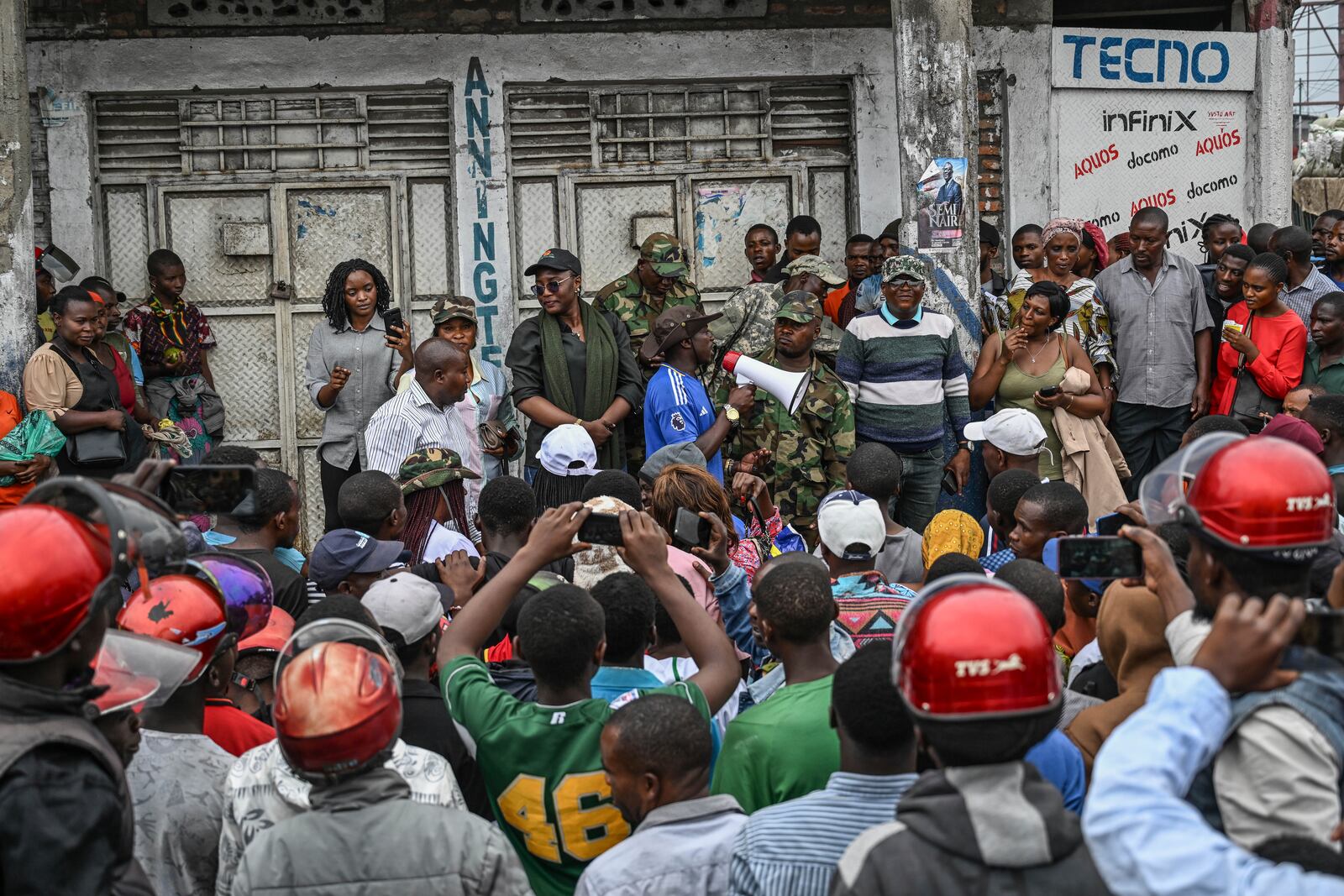 Residents listen to M23 rebel soldiers in Goma, Democratic republic of the Congo, Friday, Jan. 31, 2025. (AP Photo/Moses Sawasawa)