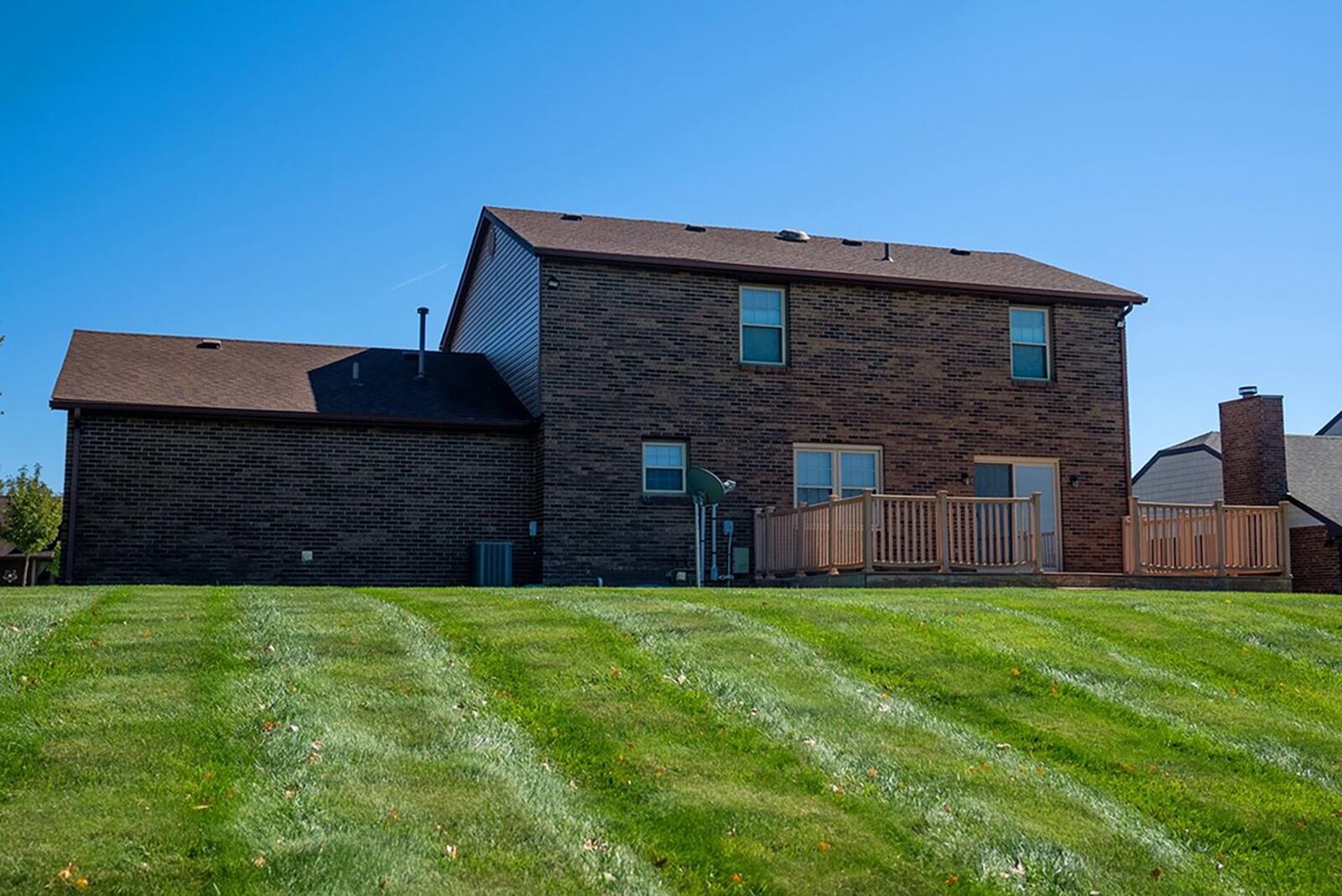 The rear has an oversized wood deck with railings and a partially fenced back yard. CONTRIBUTED PHOTO