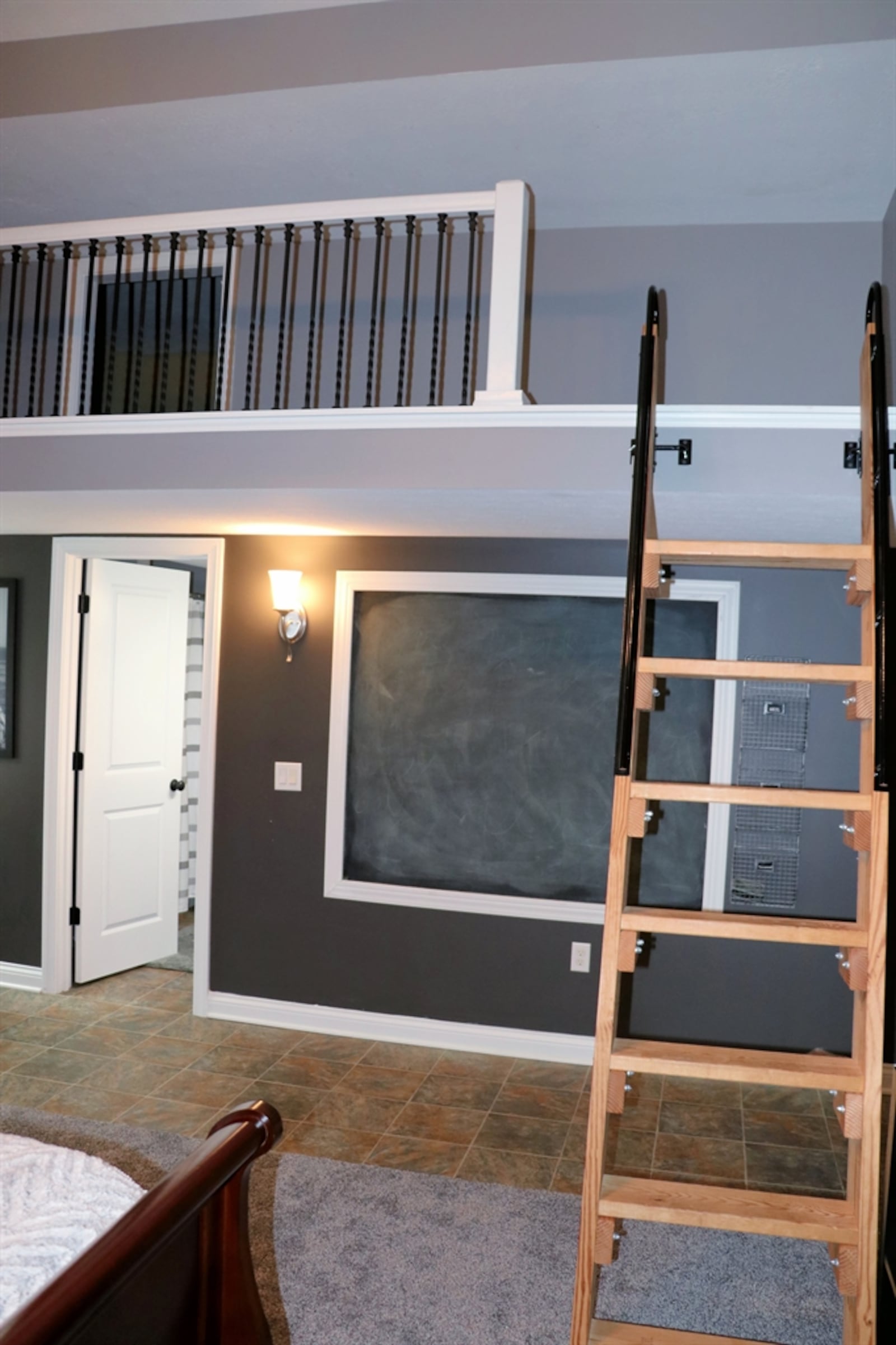 On the lower level, a 130-square-foot loft area is accessible from a ladder within a room. A wrought-iron railing wraps around the loft.