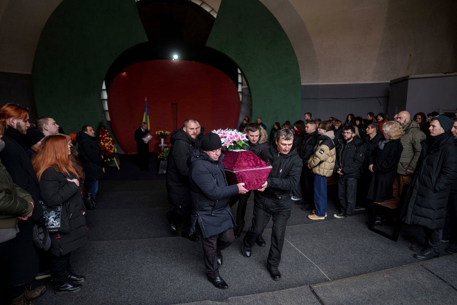 Cemetery workers carry a coffin of biologist Olesia Sokur, who was killed together with her husband neurobiologist Ihor Zyma by a Russian strike on Jan. 1, during a funeral ceremony in Kyiv, Monday, Jan. 6, 2025. (AP Photo/Evgeniy Maloletka)