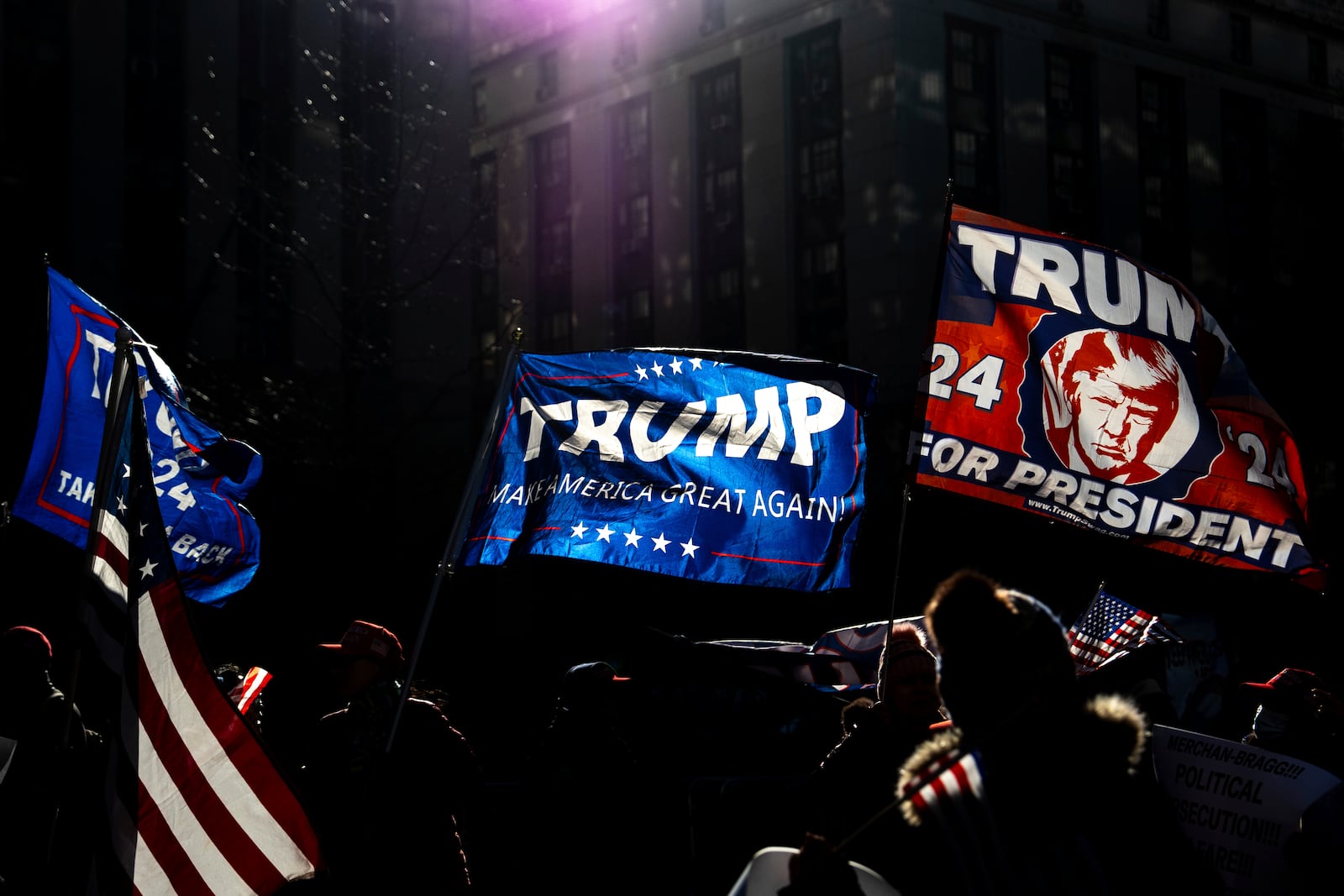 Demonstrators wave flags outside Manhattan criminal court following the sentencing in President-elect Donald Trump's hush money case, Friday, Jan. 10, 2025, in New York. (AP Photo/Julia Demaree Nikhinson)