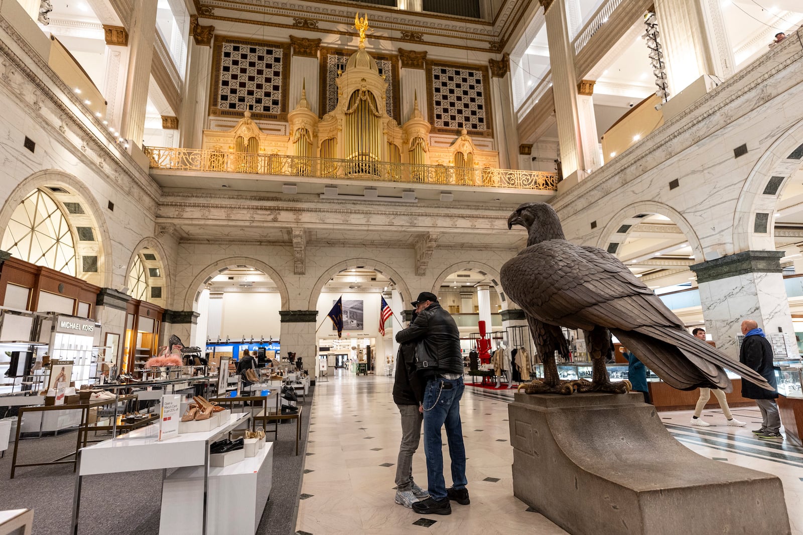 Bob Koherr, 64, and Walter Batt, 62, of Center City, Pa., share a moment together due to the closing of the Macy's and memories of their time spent together as the Wanamaker Organ, Friday, Jan. 10, 2025, in Philadelphia. (Tyger Williams/The Philadelphia Inquirer via AP)