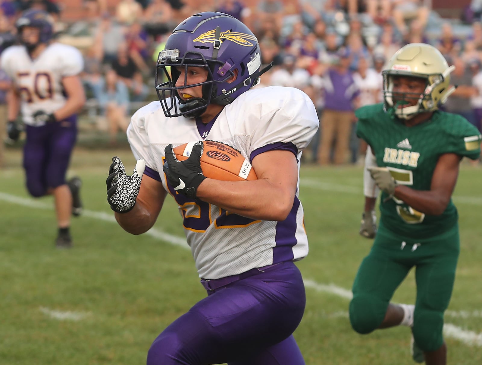 Mechanicsburg's Noah Wolf carries an interception back for a touchdown against Catholic Central. BILL LACKEY/STAFF