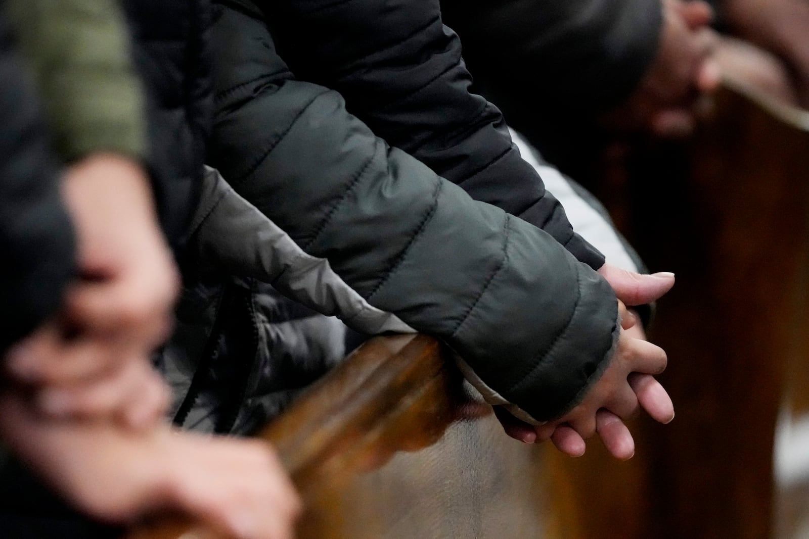 Church members hold hands together during a service at St. Rita of Cascia Parish in Chicago, Sunday, Jan. 19, 2025. (AP Photo/Nam Y. Huh)