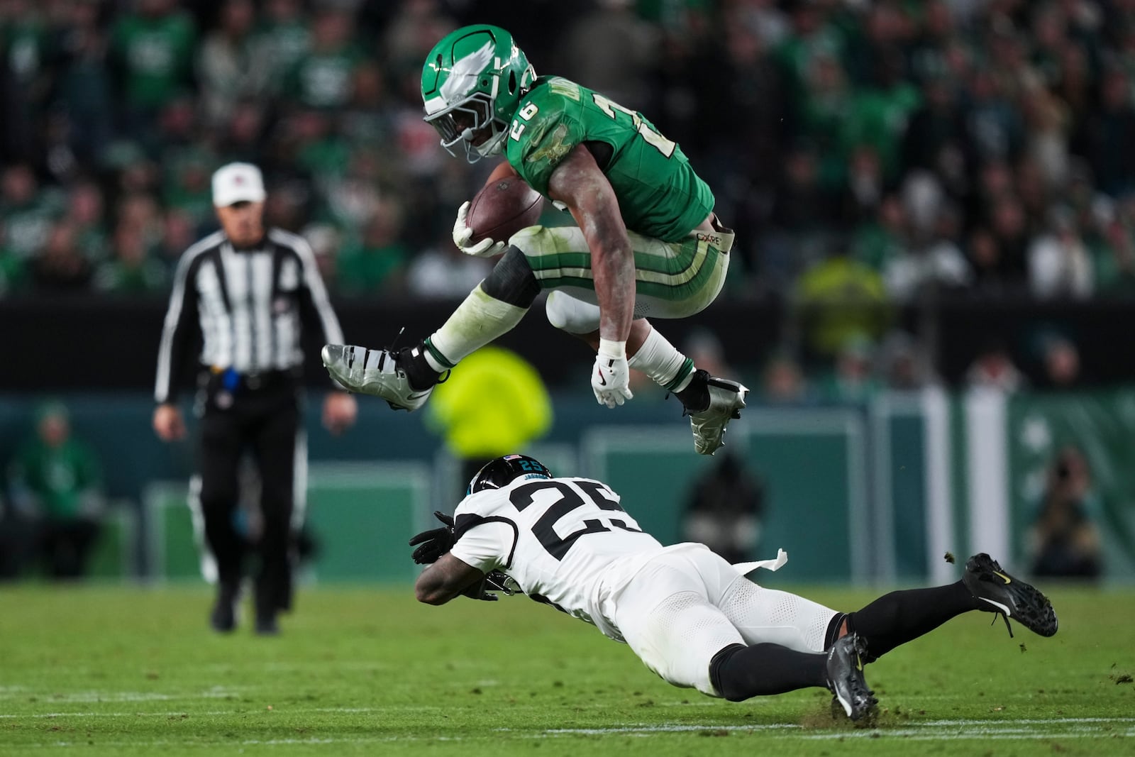 Philadelphia Eagles running back Saquon Barkley (26) leaps over Jacksonville Jaguars cornerback Ronald Darby (25) during the second half of an NFL football game Sunday, Nov. 3, 2024, in Philadelphia. (AP Photo/Matt Slocum)