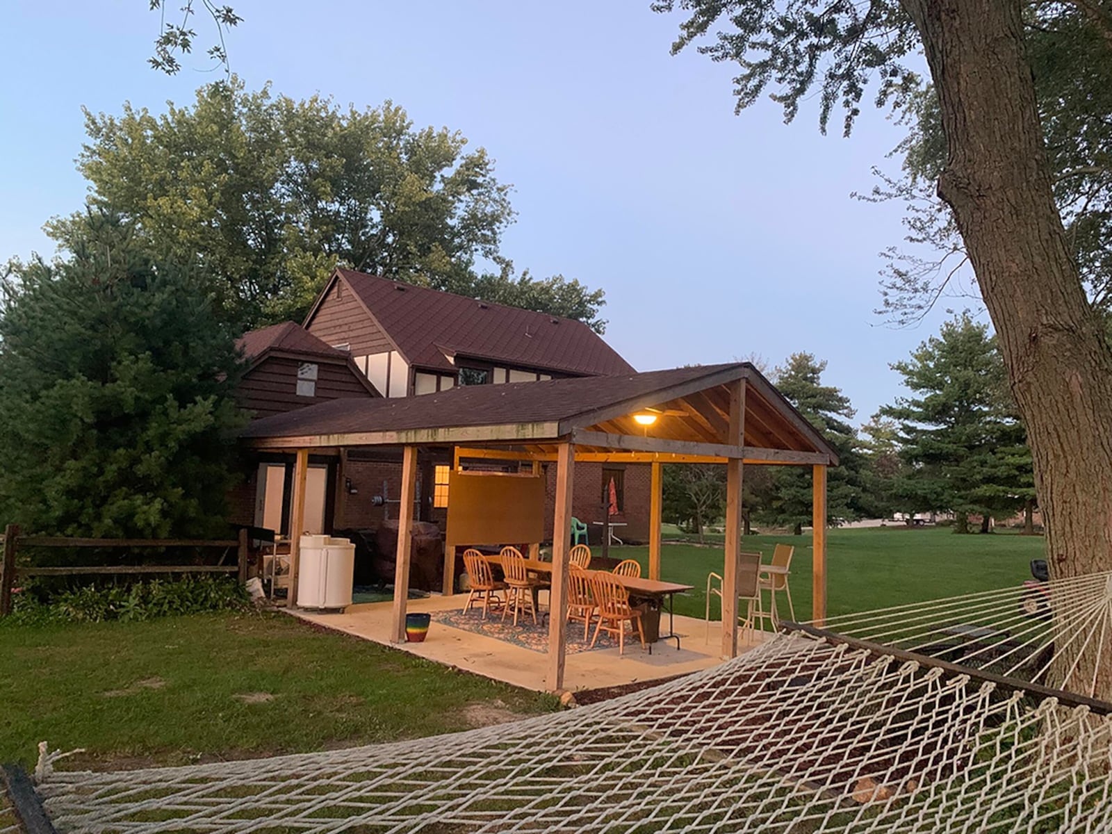 A covered patio is the highlight of the back of the home and features ceiling fans, lights, a connected wooden deck and views of the back yard. CONTRIBUTED PHOTO