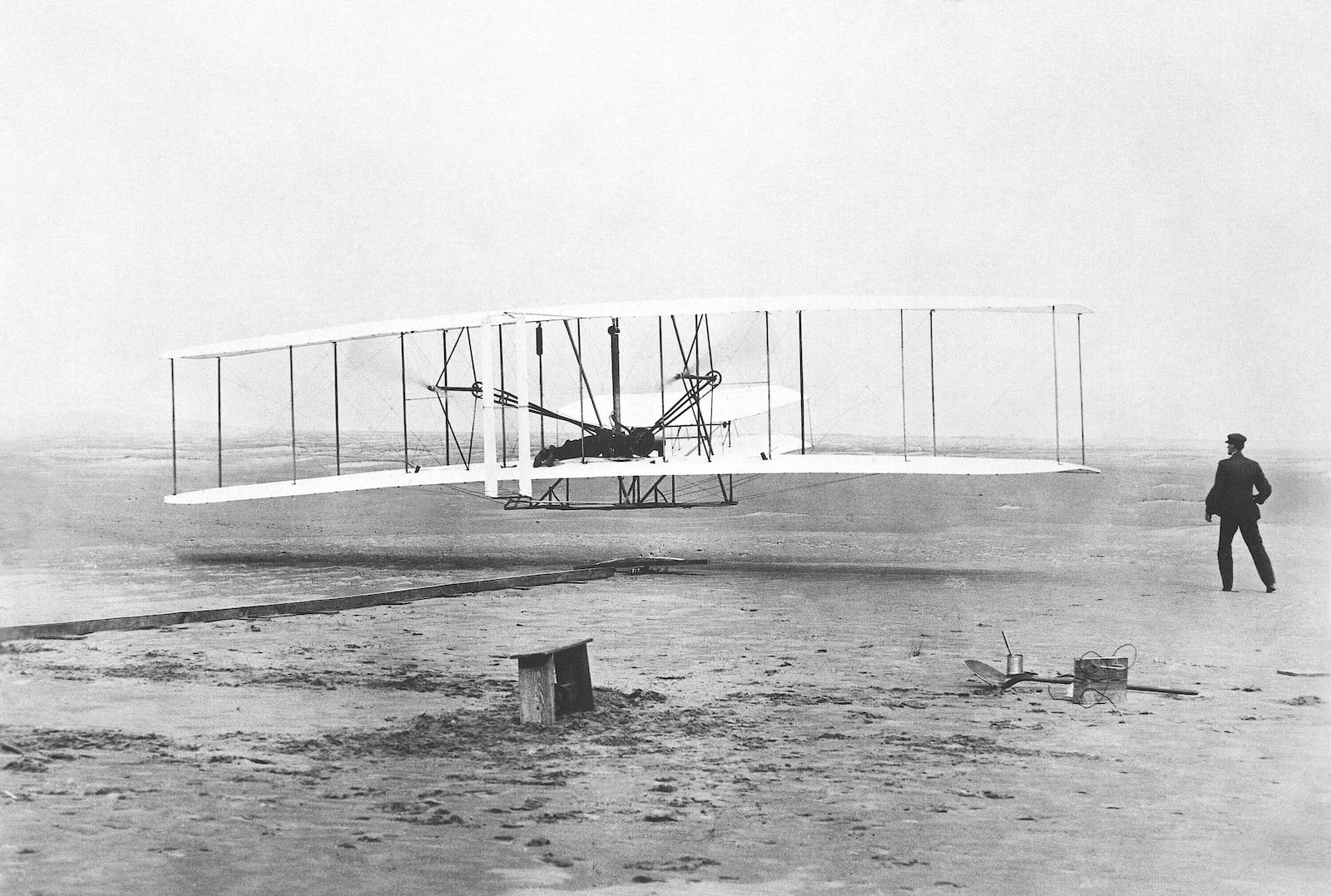 FILE - Orville Wright is at the controls of the "Wright Flyer" as his brother Wilbur Wright, right, looks on during the plane's first flight at Kitty Hawk, N.C., on Dec. 17, 1903. A backwards image of the Wright Flyer that appeared on the initial version of Ohio’s new license plate was added to the design early and never changed or questioned throughout the approval process, according to public records obtained by The Associated Press. The error was fixed only after the public unveiling in October drew attention to it. (John T. Daniels/The Virginian-Pilot via AP, File)