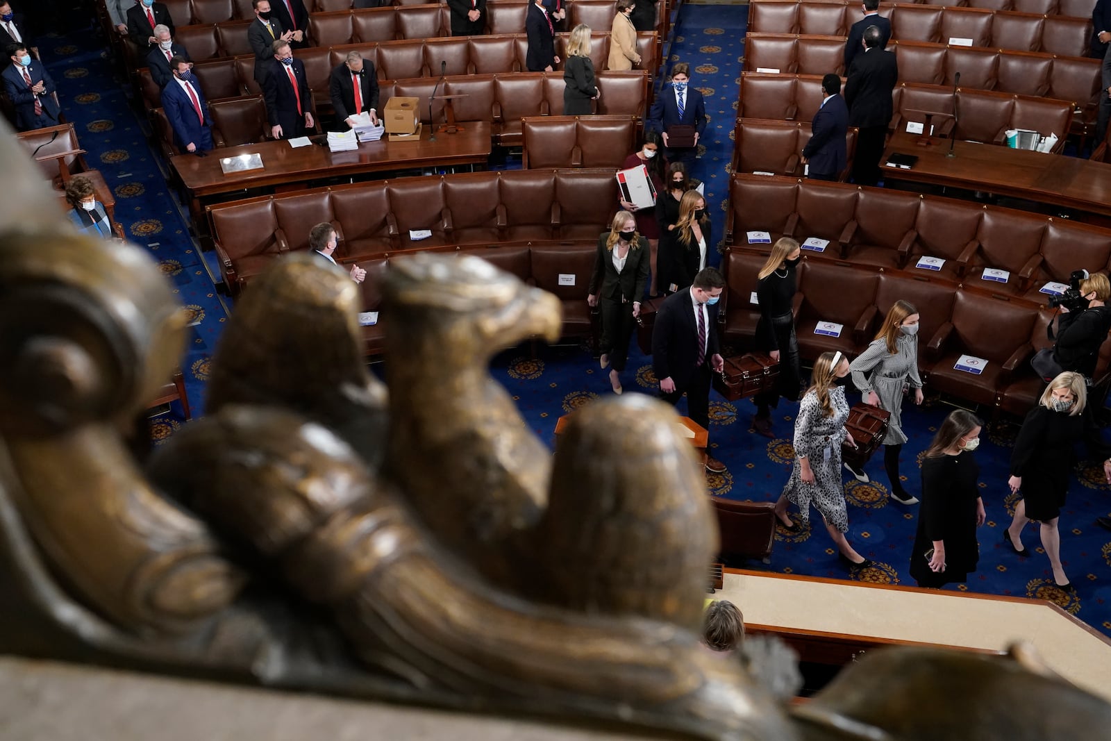 FILE - Senate pages carry boxes containing Electoral College votes into a joint session of the House and Senate convenes to count the electoral votes cast in November's election, at the Capitol, Wednesday, Jan 6, 2021. (AP Photo/Andrew Harnik, File)