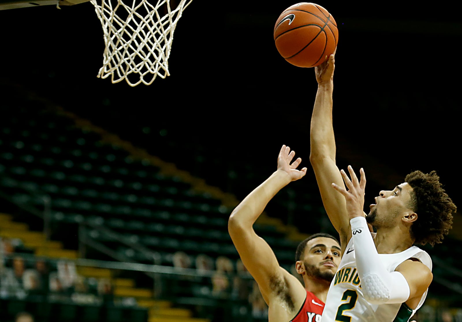 Wright State guard Tanner Holden scores against Youngstown State guard Daniel Ogoro during a Horizon League game at the Nutter Center in Fairborn Jan. 9, 2021. Wright State won 93-55. Contributed photo by E.L. Hubbard