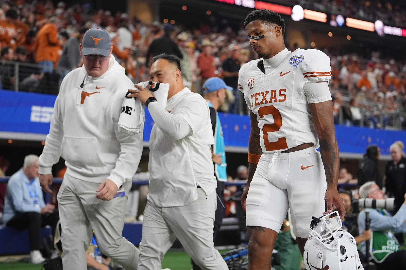 Texas wide receiver Matthew Golden (2) walks off the field with trainers during the first half of the Cotton Bowl College Football Playoff semifinal game against Ohio State, Friday, Jan. 10, 2025, in Arlington, Texas. (AP Photo/Julio Cortez)