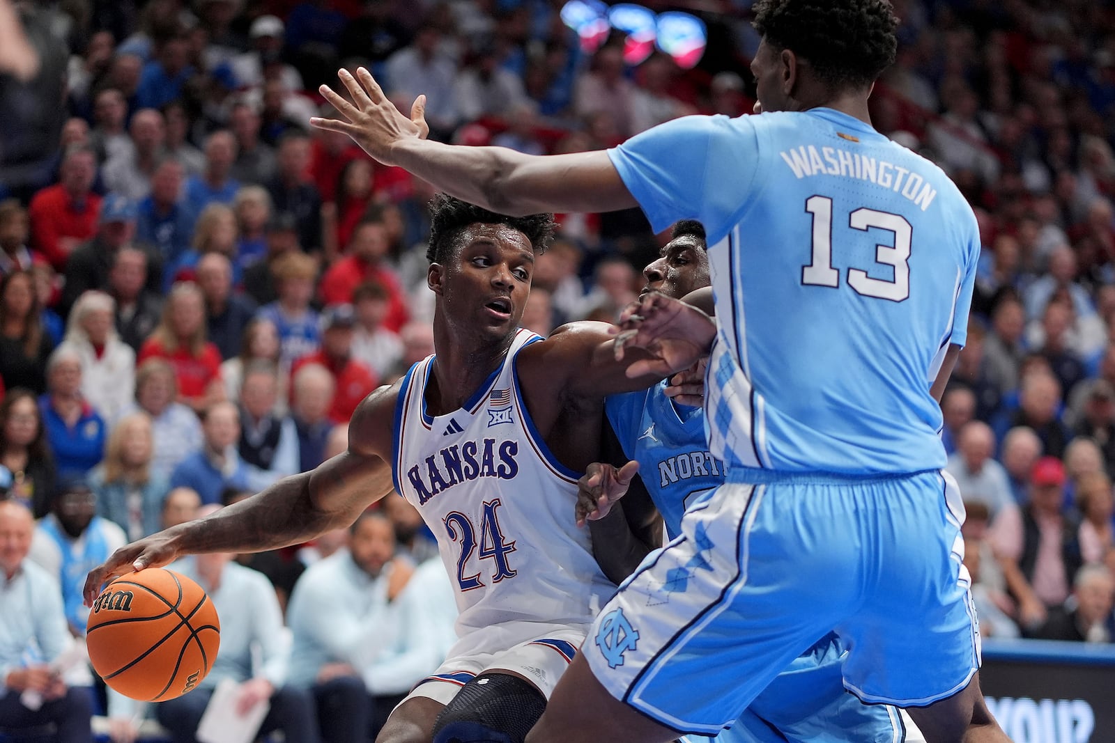 Kansas forward KJ Adams Jr. (24) looks to pass around North Carolina forward Jalen Washington (13) during the first half of an NCAA college basketball game Friday, Nov. 8, 2024, in Lawrence, Kan. (AP Photo/Charlie Riedel)