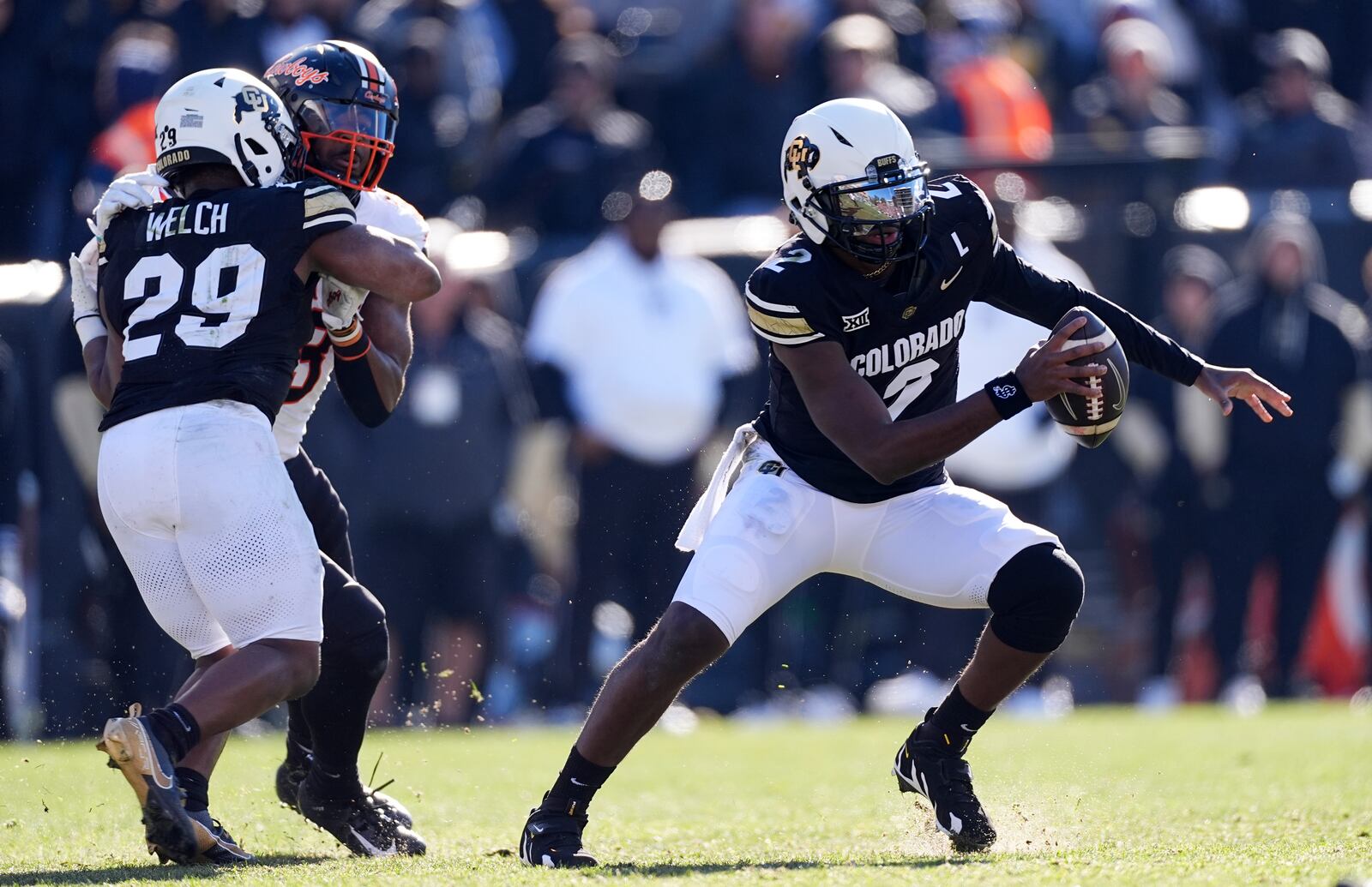 Colorado running back Micah Welch, front left, blocks Oklahoma State safety Kade Welcher to create running room for Colorado quarterback Shedeur Sanders in the first half of an NCAA college football game Friday, Nov. 29, 2024, in Boulder, Colo. (AP Photo/David Zalubowski)