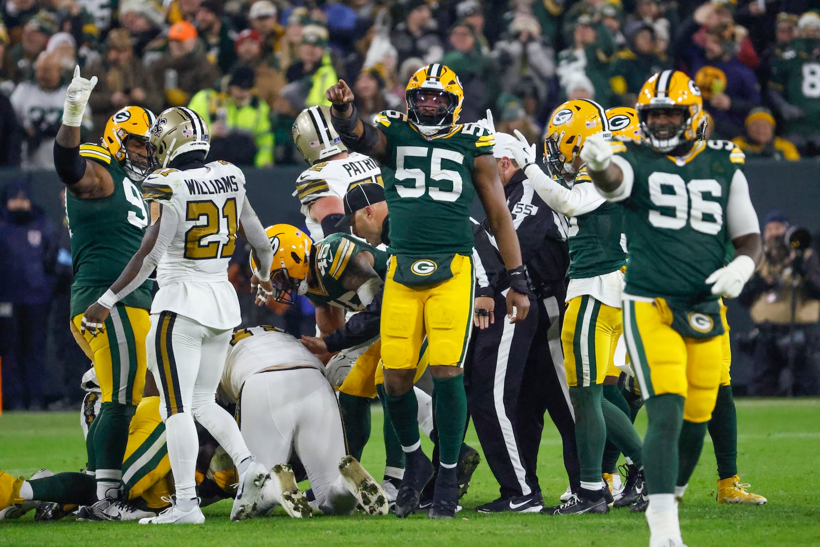 Green Bay Packers defensive end Kingsley Enagbare (55) and defensive tackle Colby Wooden (96) celebrate a fumble recovery during the first half of an NFL football game against the New Orleans Saints, Monday, Dec. 23, 2024, in Green Bay, Wis. (AP Photo/Mike Roemer)