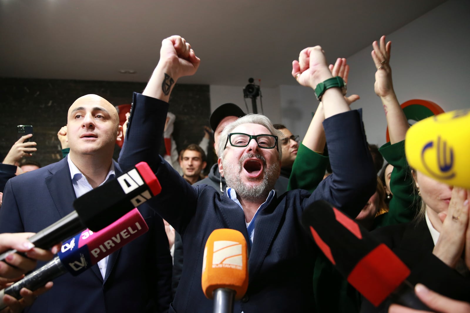 From left, Nika Melia and Nika Gvaramia, leaders of Coalition for Changes, react while talking to journalists at coalition's headquarters after polls closing at the parliamentary election in Tbilisi, Georgia, Saturday, Oct. 26, 2024. (AP Photo/Zurab Tsertsvadze)