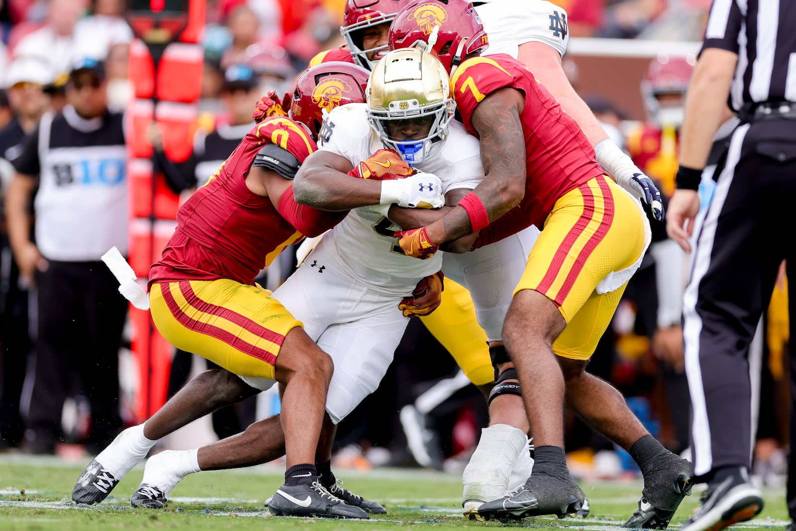 Notre Dame running back Jeremiyah Love, center, is tackled by Southern California safetys Akili Arnold, left, and Kamari Ramsey during the first half of an NCAA football game, Saturday, Nov. 30, 2024, in Los Angeles. (AP Photo/Ryan Sun)