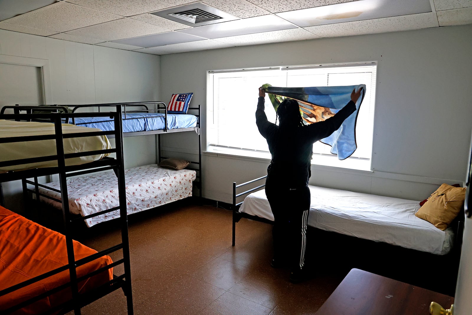 Taylor Cobb makes the beds in one of the family size rooms Tuesday, Sept. 5, 2023 as she helps get Norm's Place homeless shelter ready to reopen. BILL LACKEY/STAFF