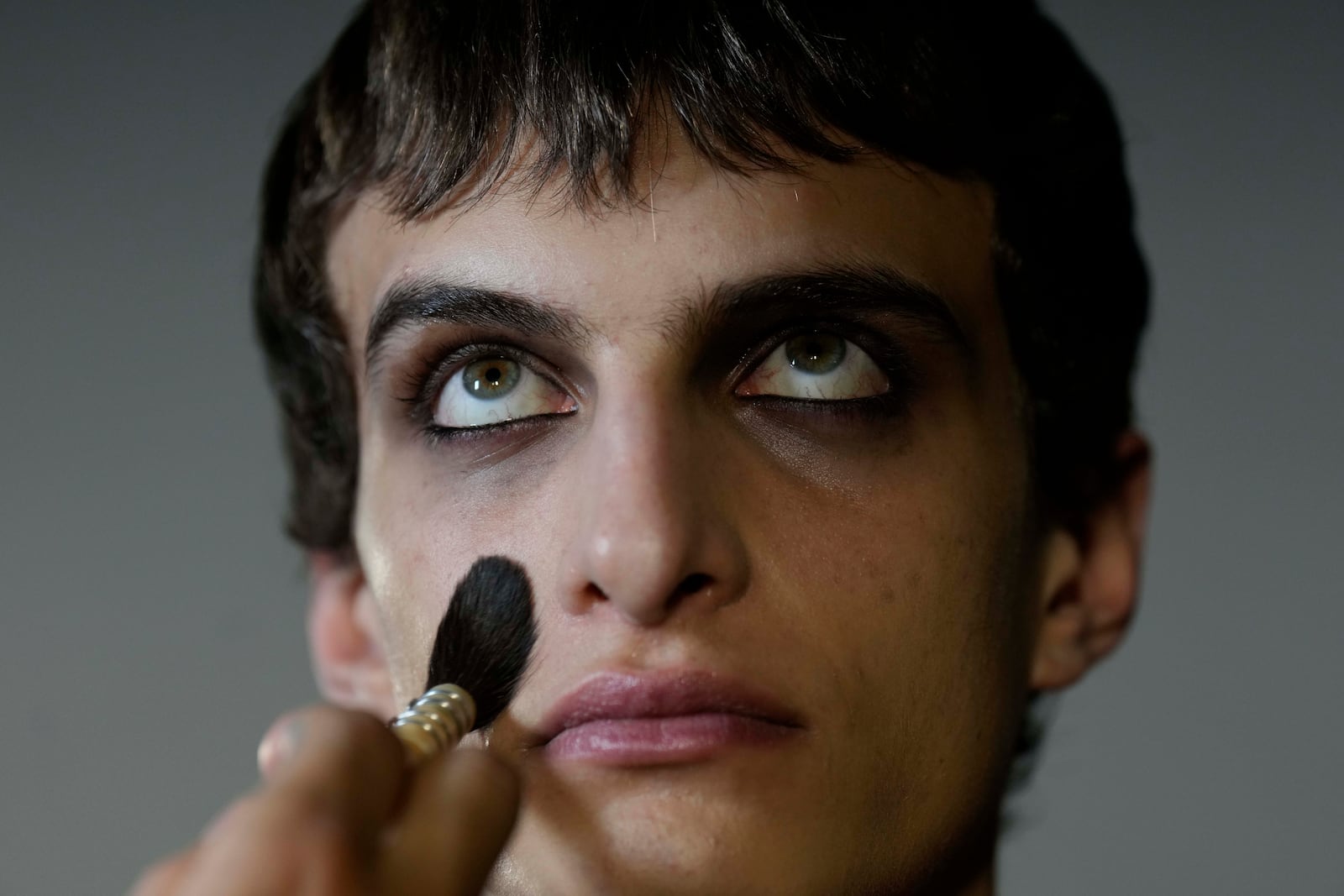 Model Antoine gets made up by a make up artist in the backstage prior a Marni Fall/Winter 2025-2026 Womenswear fashion show, during the Fashion Week, in Milan, Italy, Wednesday, Feb. 26, 2025. (AP Photo/Luca Bruno)