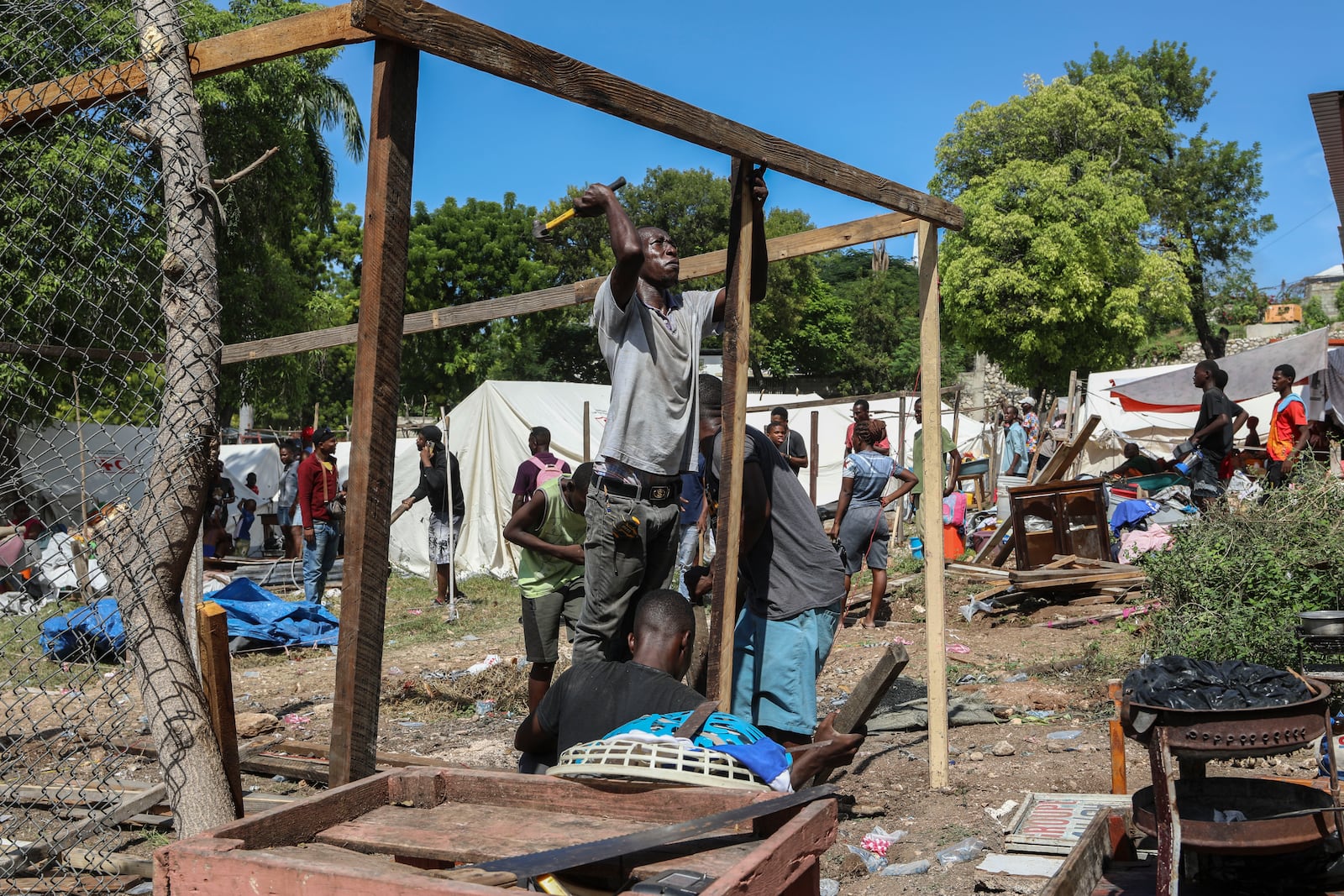 Residents of the Nazon neighborhood displaced by gang violence construct a tent encampment, in Port-au-Prince, Haiti, Friday, Nov. 15, 2024. (AP Photo/Odelyn Joseph)