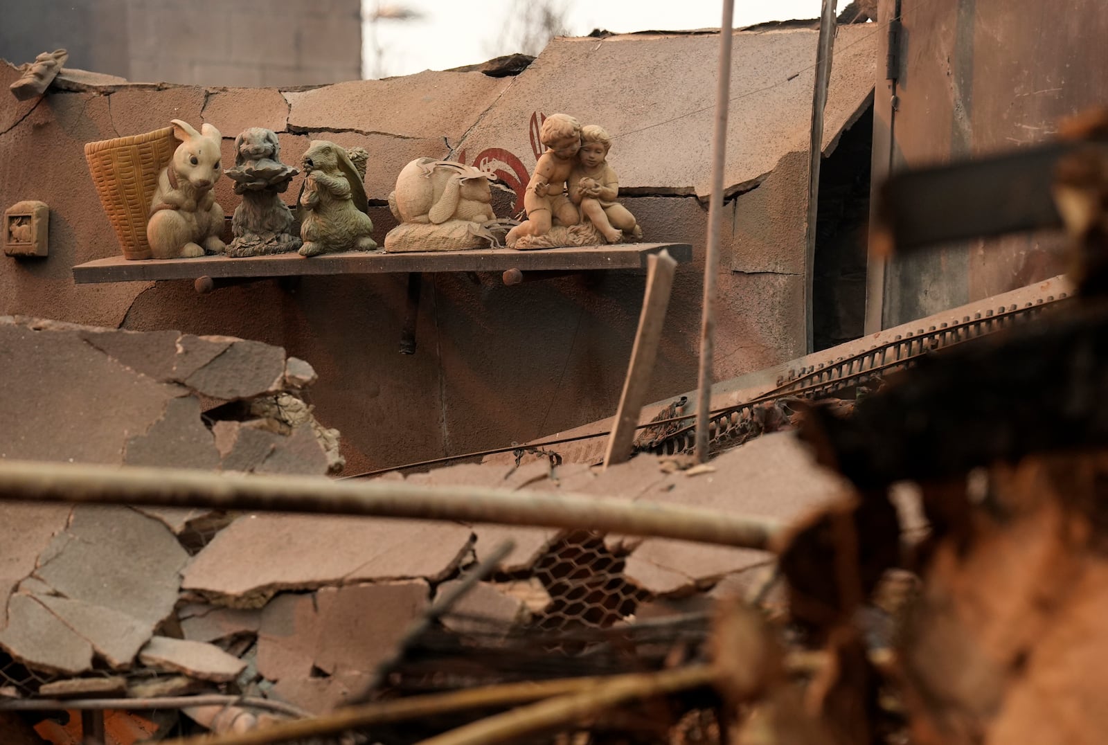 Charred bunny sculptures sit on a shelf amid debris inside the destroyed Bunny Museum, Thursday, Jan. 9, 2025, in the Altadena section of Pasadena, Calif. (AP Photo/Chris Pizzello)