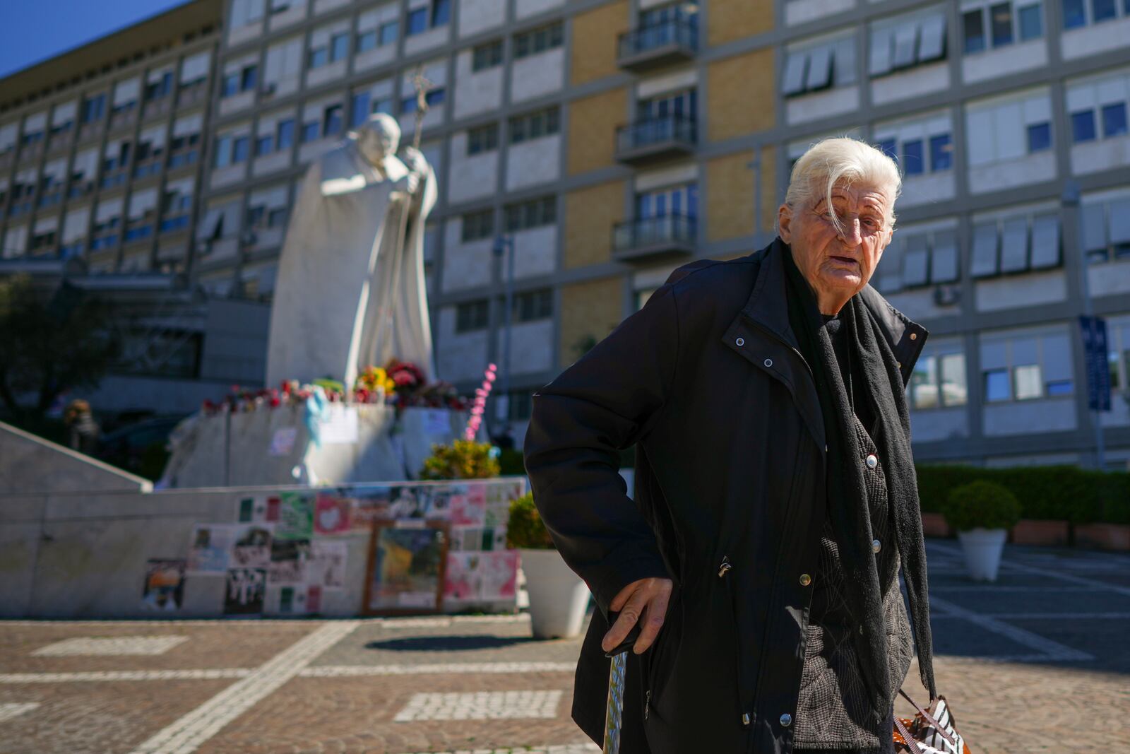 People pray for Pope Francis in front of the Agostino Gemelli Polyclinic, in Rome, Tuesday, March 18, 2025, where the Pontiff is hospitalized since Feb. 14. (AP Photo/Andrew Medichini)