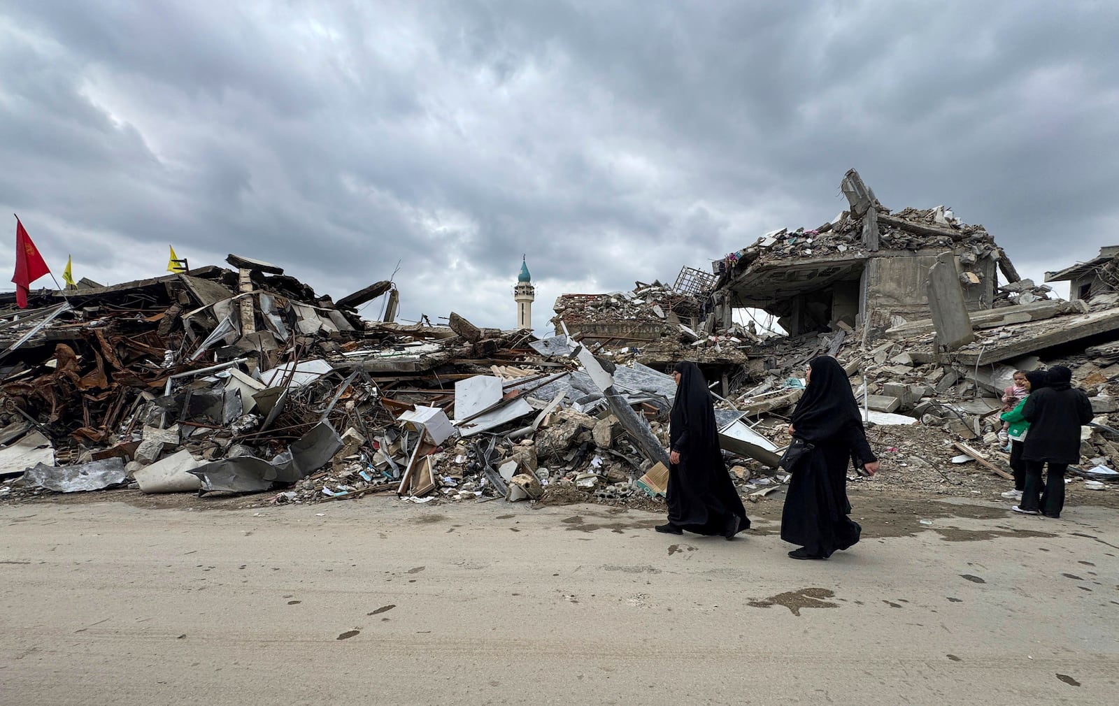 Residents walk past destroyed buildings as they return to Nabatiyeh, southern Lebanon, Thursday, Nov. 28, 2024 following a ceasefire between Israel and Hezbollah that went into effect on Wednesday. (AP Photo/Bassam Hatoum)