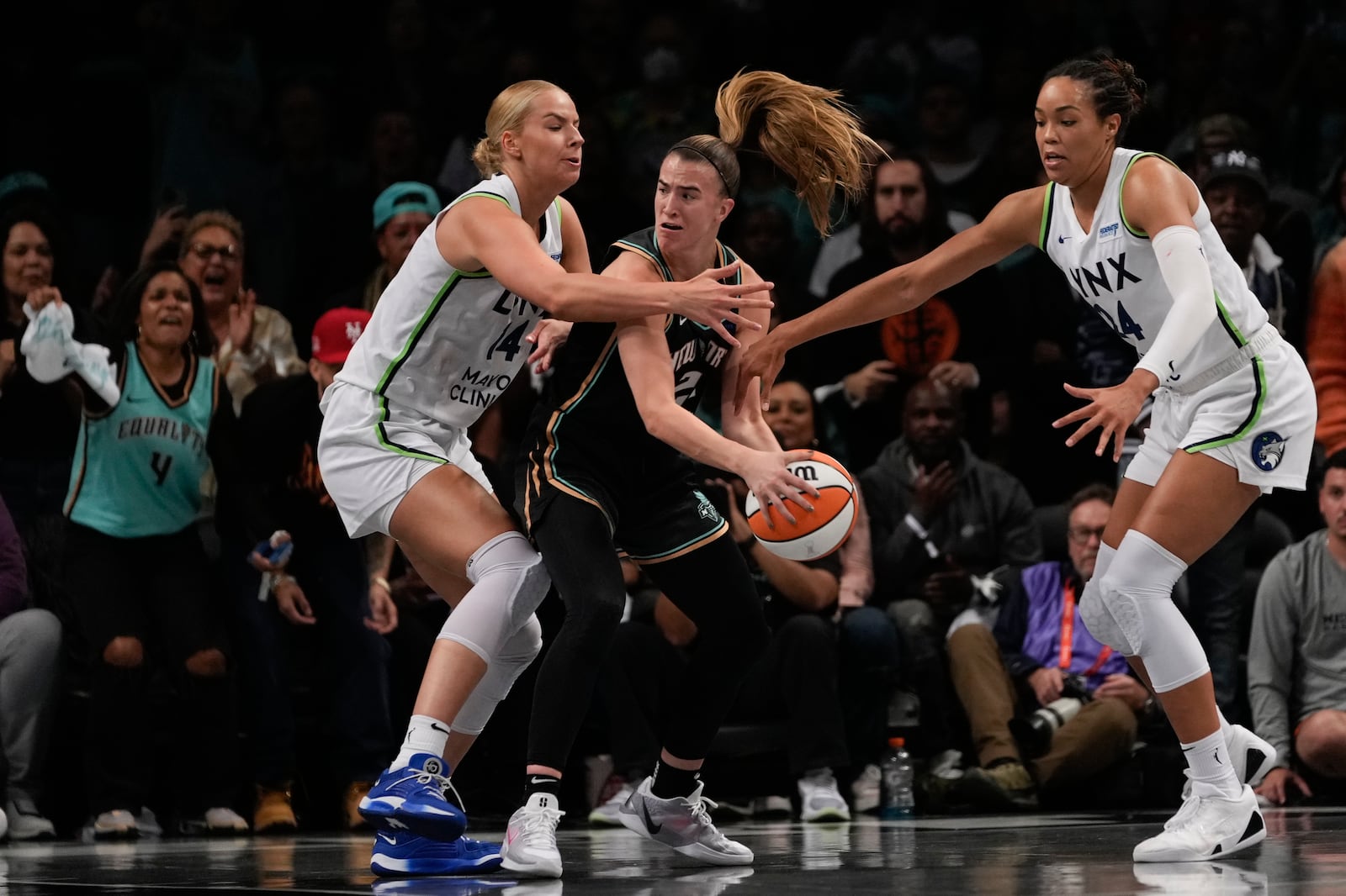 New York Liberty guard Sabrina Ionescu (20) is double teamed by Minnesota Lynx forward Dorka Juhasz (14) and forward Napheesa Collier (24) during the third quarter of Game 5 of the WNBA basketball final series, Sunday, Oct. 20, 2024, in New York. (AP Photo/Pamela Smith)