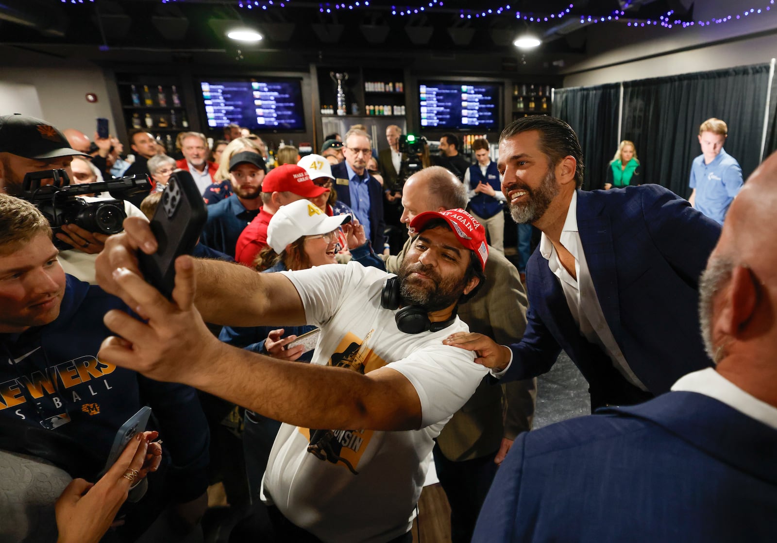 Donald Trump Jr. takes photos with supporters after a town hall meeting Monday, March 17, 2025, in Oconomowoc, Wis. (AP Photo/Jeffrey Phelps)