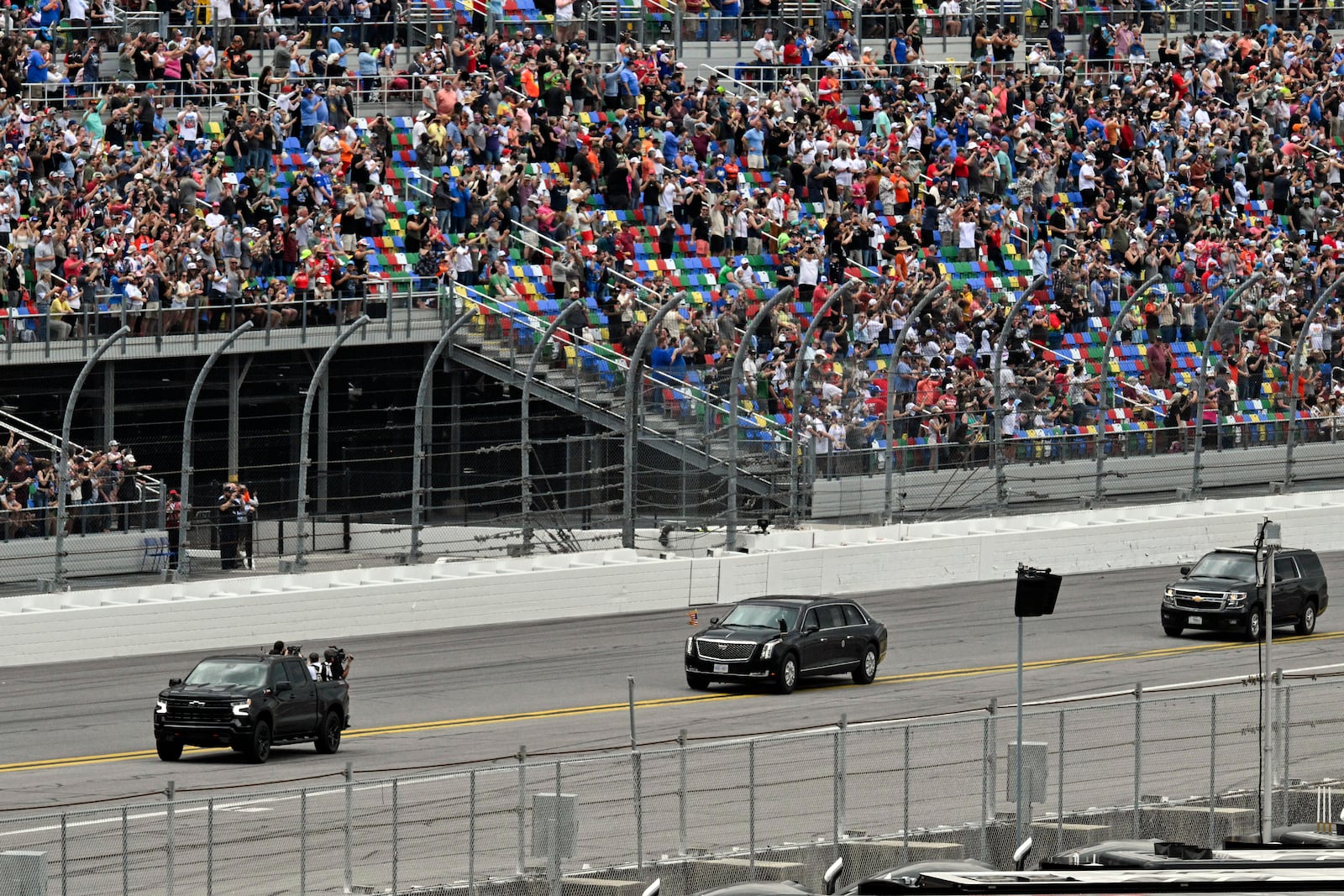 President Donald Trump, center, in the presidential limousine known as "The Beast" does a lap around the track at the NASCAR Daytona 500 auto race at Daytona International Speedway, Sunday, Feb. 16, 2025, in Daytona Beach, Fla. (Pool via AP)