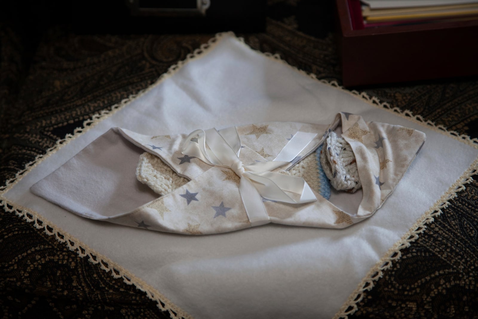 Clothing and blankets worn by baby Lux Siloam are spread out on the sofa of Doneysha Smith and Lynnell Logan, mother and grandmother of Lux, in Sherwood, Arkansas, Tuesday, Feb. 11, 2025. After being stillborn at 18 weeks, Lux's body was stolen and sold to traffickers in two states, prompting an FBI investigation. A proposed law, known as Lux's Law, would prohibit the sale of dead bodies that were intended to be cremated or buried and establish penalties in Arkansas. (AP Photo/Katie Adkins)