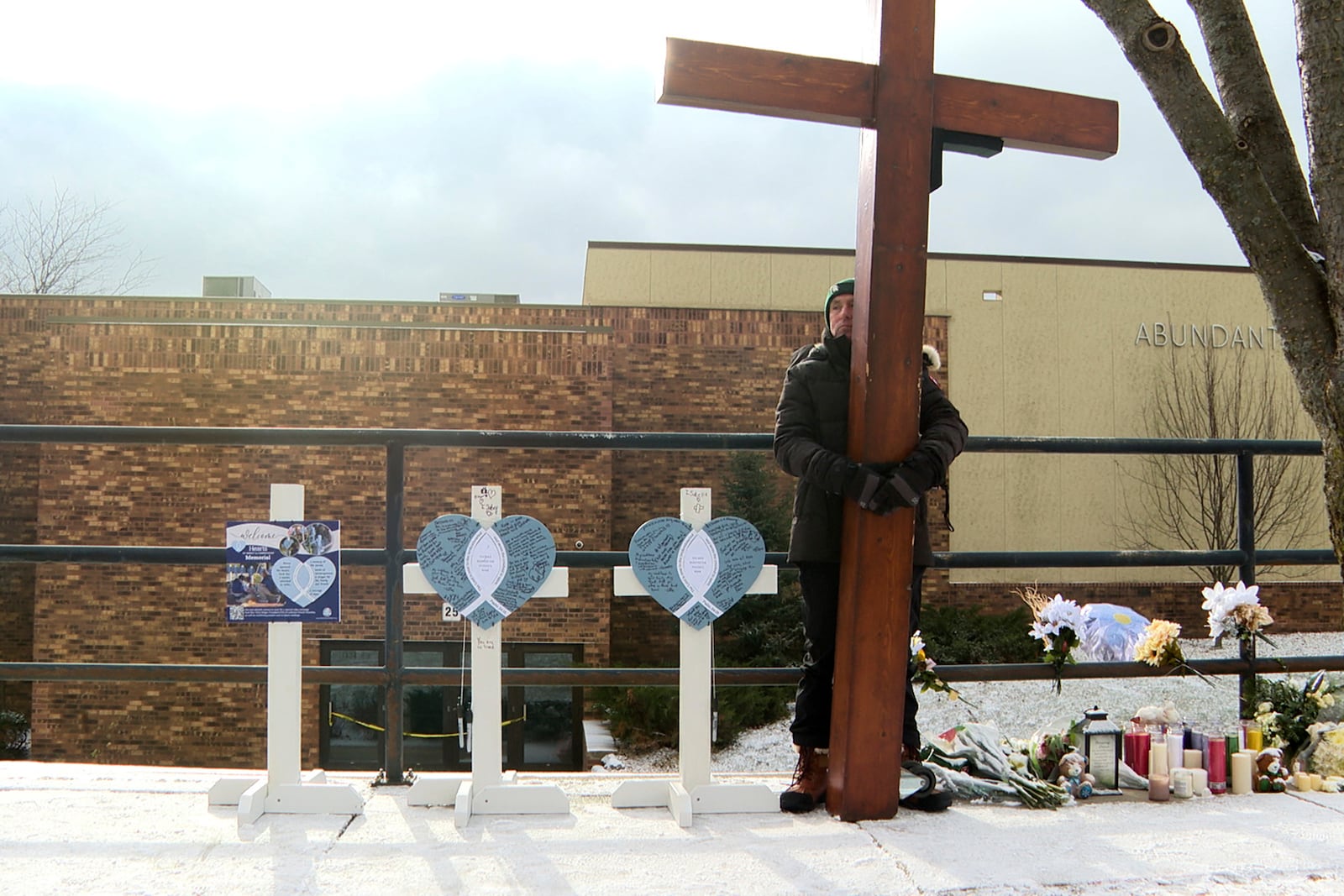 Dan Beazley stands with the homemade cross he brought from Michigan for victims of a shooting at Abundant Life Christin School on Wednesday, Dec. 18, 2024 in Madison, Wis. (AP photo/Mark Vancleave)