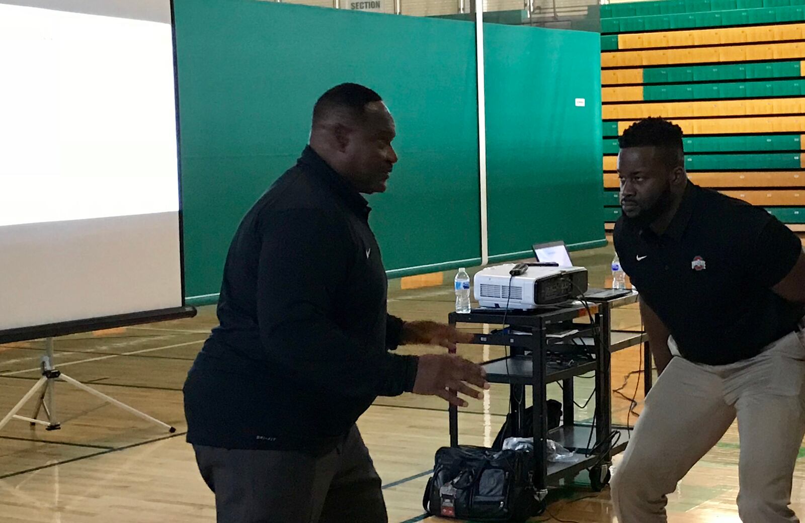 Ohio State defensive line coach Larry Johnson (left) shows how he teaches pass-rush technique in a clinic at Northmont High School.