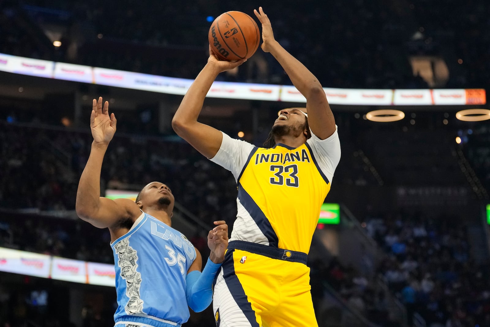 Indiana Pacers center Myles Turner (33) shoots next to Cleveland Cavaliers forward Isaac Okoro (35) in the first half of an NBA basketball game, Sunday, Jan. 12, 2025, in Cleveland. (AP Photo/Sue Ogrocki)