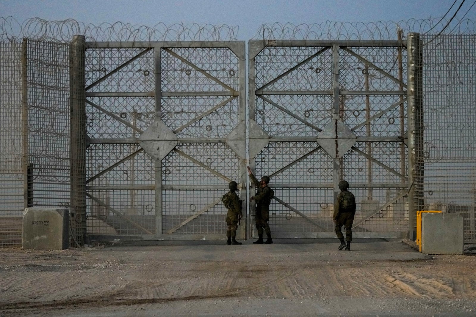 Israeli soldiers close the gate of Erez Crossing after trucks carrying humanitarian aid entered the Gaza Strip, in southern Israel, Monday, Oct. 21, 2024. (AP Photo/Tsafrir Abayov)