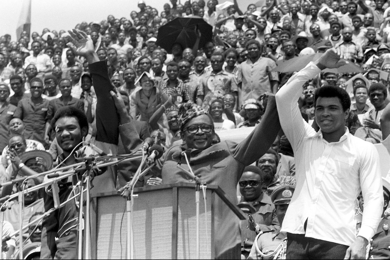 FILE - This is a Sept. 22, 1974 file photo of Zaire's President Mobutu Sese Seko, center, as he raises the arms of heavyweight champ George Foreman, left, and Muhammad Ali, right, in Kinshasa, Zaire. (AP Photo/Horst Faas, File)