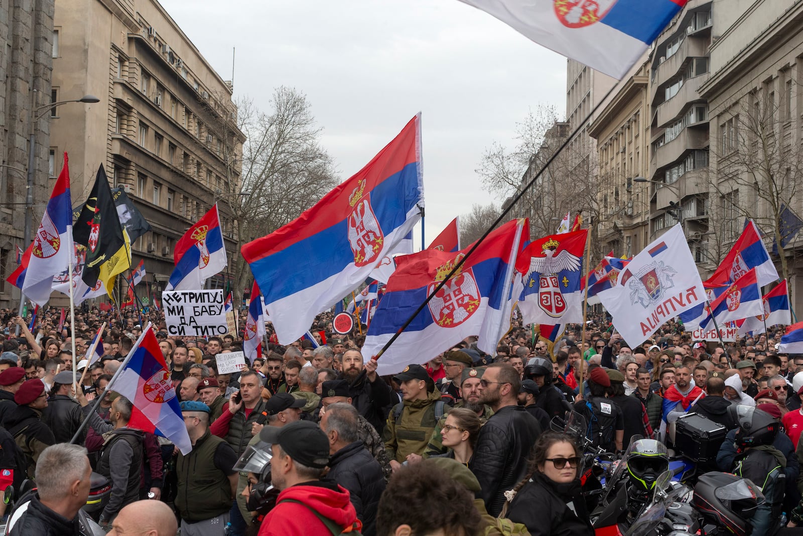 Protesters block a street while waving Serbian flags during a major anti-corruption rally led by university students in Belgrade, Serbia, Saturday, March 15, 2025. (AP Photo/Marko Drobnjakovic)