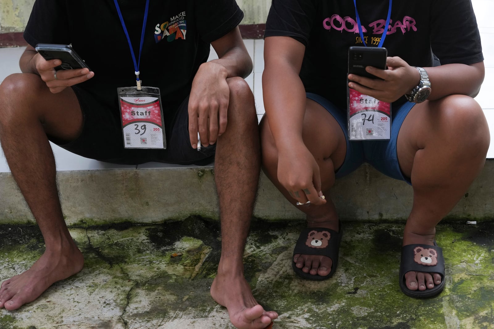 People rescued from a scam center in Myanmar use their mobile phones at a temporary shelter in Jakarta, Indonesia, Tuesday, March 4, 2025. (AP Photo/Achmad Ibrahim)