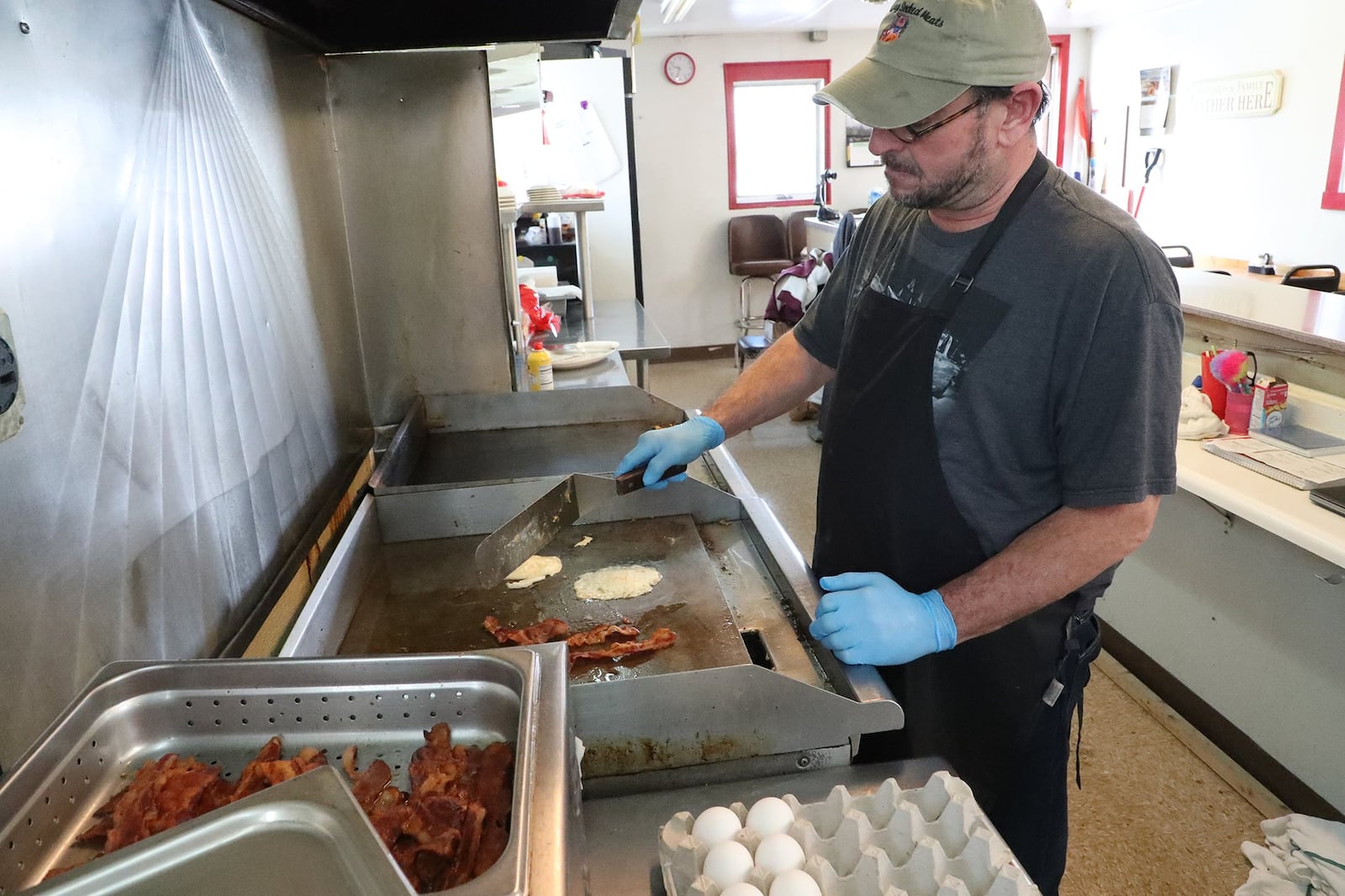 Todd Midgley, co-owner of All Inn Diner & Pizzeria, cooks breakfast on the grill. BILL LACKEY/STAFF