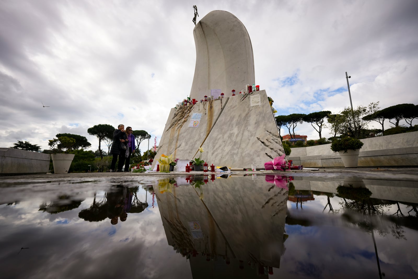 People pray in front of the Agostino Gemelli Polyclinic, in Rome, Thursday, March 13, 2025, where Pope Francis is hospitalized since Friday, Feb. 14. (AP Photo/Andrew Medichini)