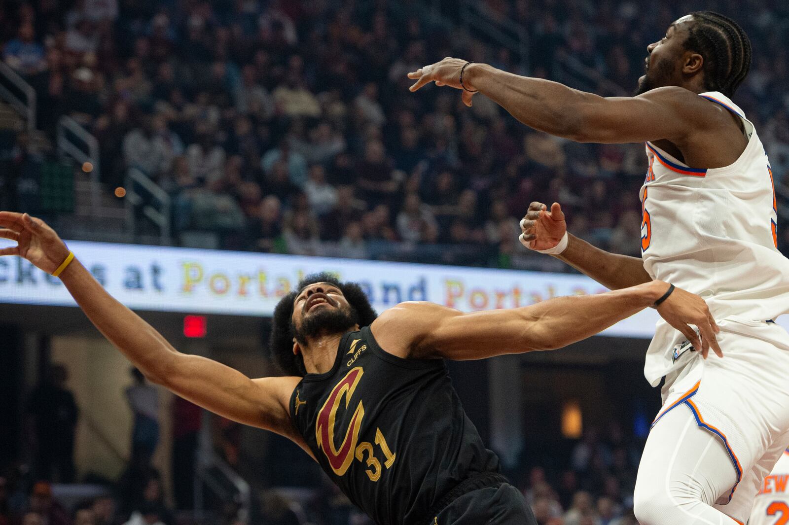 Cleveland Cavaliers' Jarrett Allen (31) watches his shot along with New York Knicks' Ariel Hukporti, right, during the first half of an NBA basketball game in Cleveland, Friday, Feb. 21, 2025. (AP Photo/Phil Long)