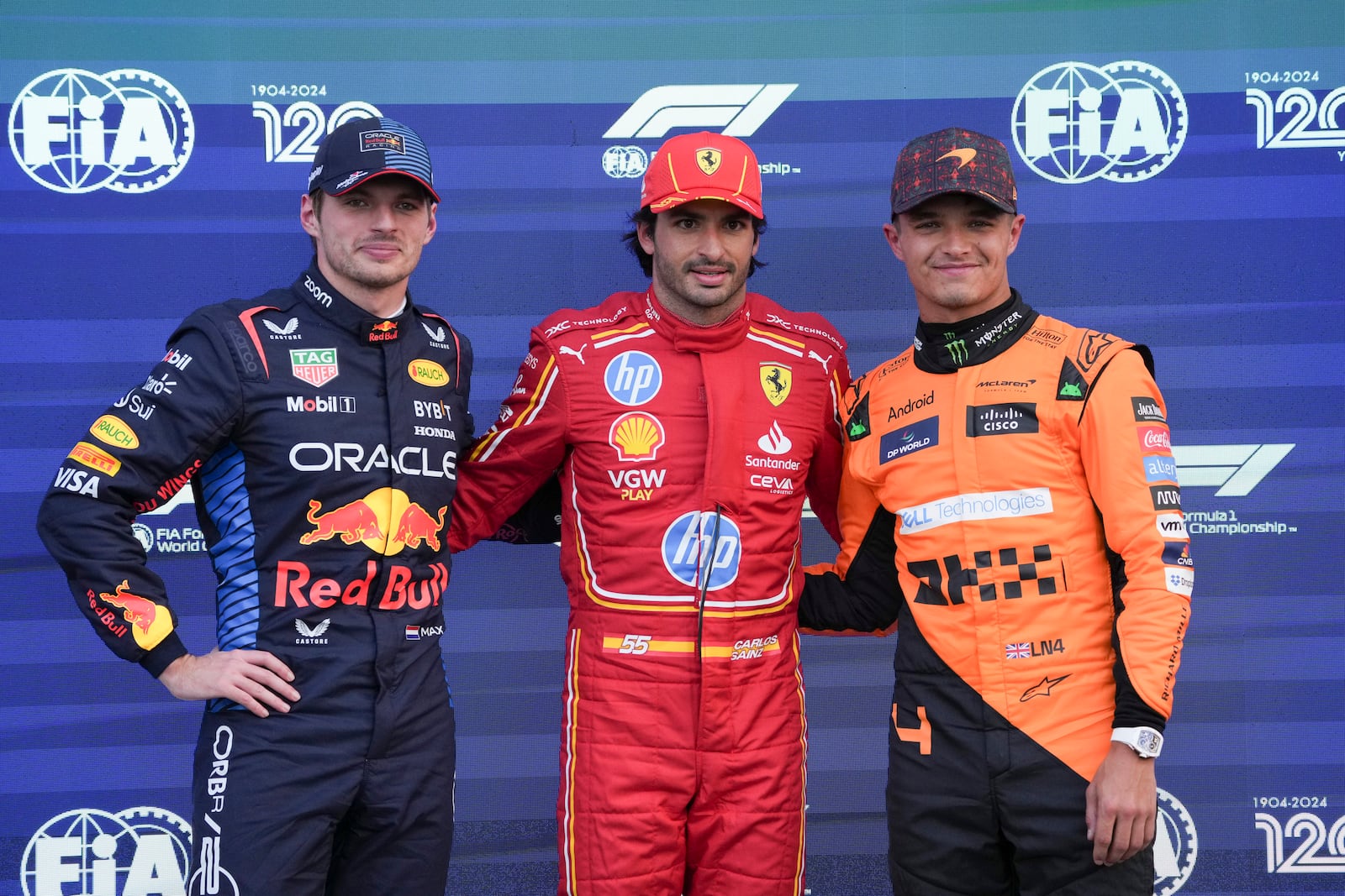 Ferrari driver Carlos Sainz, center, of Spain, poses for photos with Red Bull driver Max Verstappen, left, of the Netherlands, second place, and McLaren driver Lando Norris, of Britain, after winning the pole position a day ahead of the Formula One Mexico Grand Prix auto race at the Hermanos Rodriguez racetrack in Mexico City, Saturday, Oct. 26, 2024. (AP Photo/Fernando Llano)