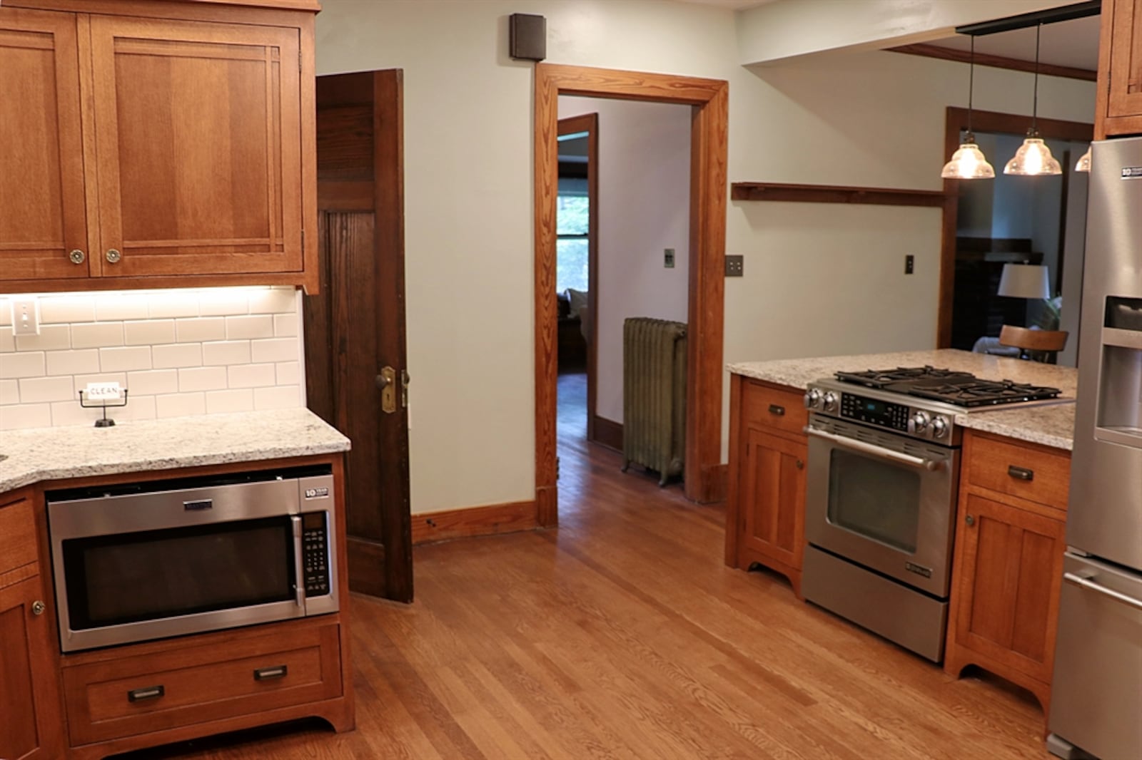 Custom cabinetry blends well with the original refinished woodwork and surrounds the corner sink and additional appliances.