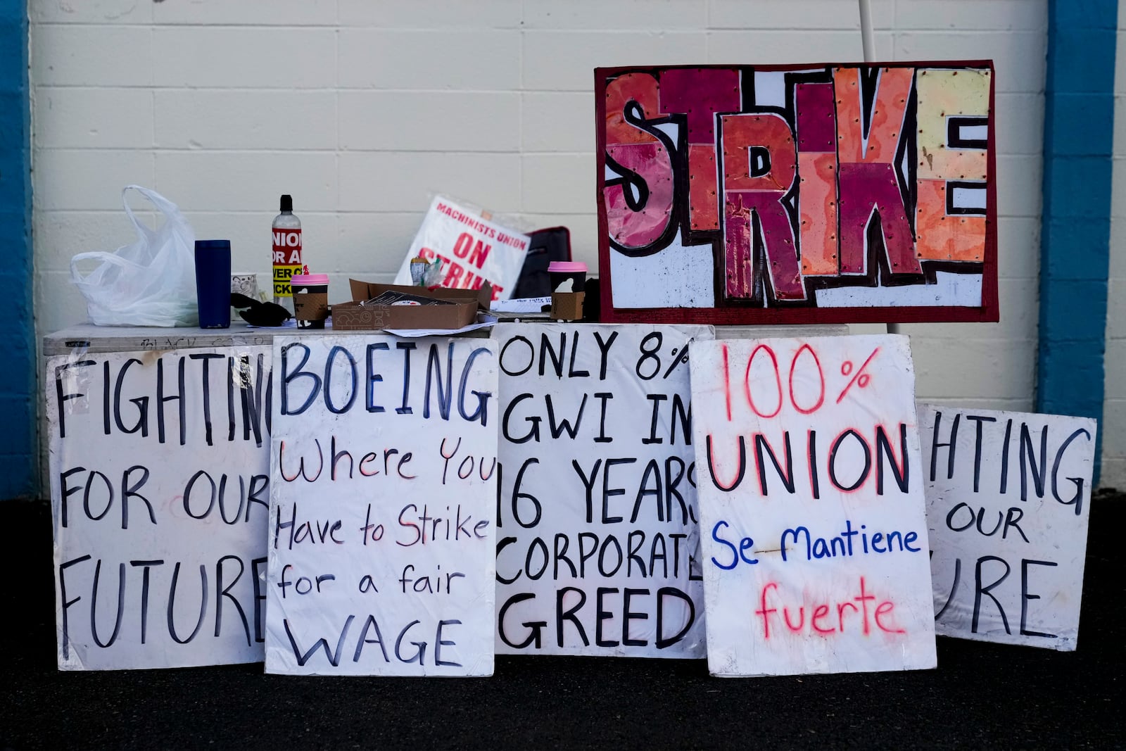 Strike signs line a table outside the Aerospace Machinists Union hall as Boeing employees on strike vote on a new contract offer from the company, Wednesday, Oct. 23, 2024, in Renton, Wash. (AP Photo/Lindsey Wasson)