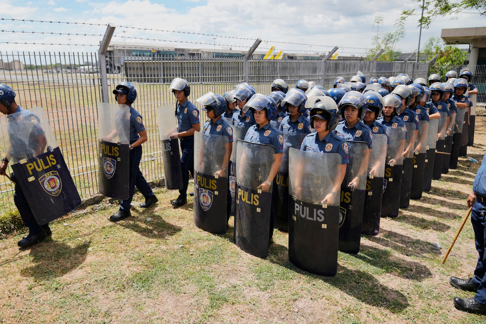 Security officials stand outside Villamor Air Base after former President Rodrigo Duterte was arrested, Tuesday, March 11, 2025, near Manila, Philippines. (AP Photo/Aaron Favila)