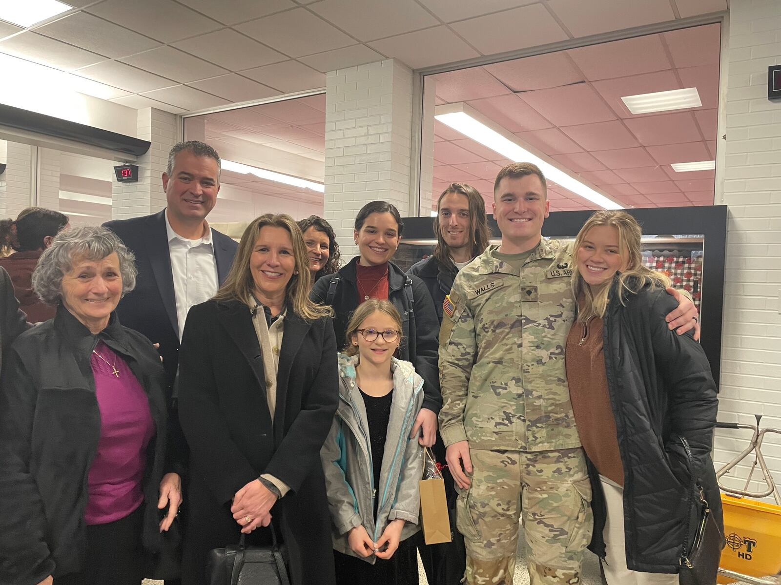 Spc. Max Walls of Cincinnati stands with family and friends, including in front row, left to right, his grandmother Suzanne Zook, his mother, Alicia Walls, niece Arden and his fiancée, Casey Kingsland. In back, from left to right are his father, Jordan Walls, aunt Amber Yount, sister Madeline Walls and friend Angus Matthews. left,JEN BALDUF/STAFF