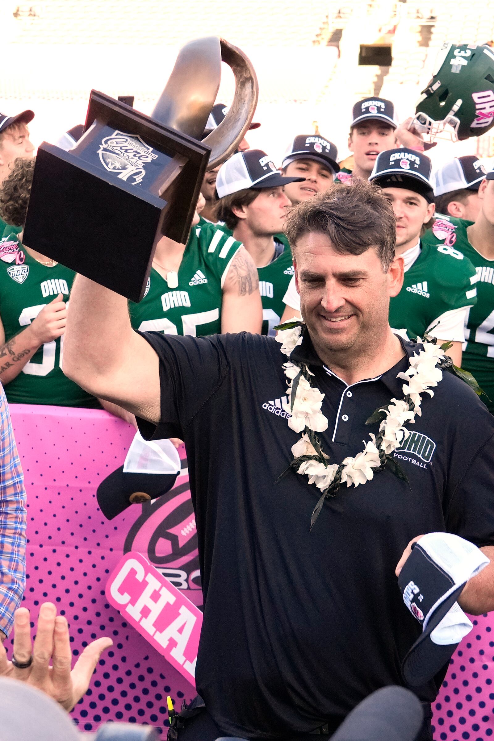 Ohio head coach Brian Smith holds up the Cure Bowl Championship trophy after defeating Jacksonville State in NCAA college football game, Friday, Dec. 20, 2024, in Orlando, Fla. (AP Photo/John Raoux)