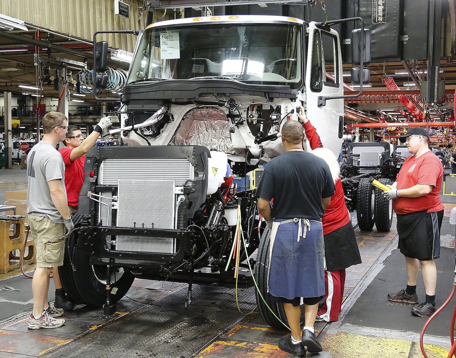 Workers at Navistar assemble a truck cab. Bill Lackey/Staff