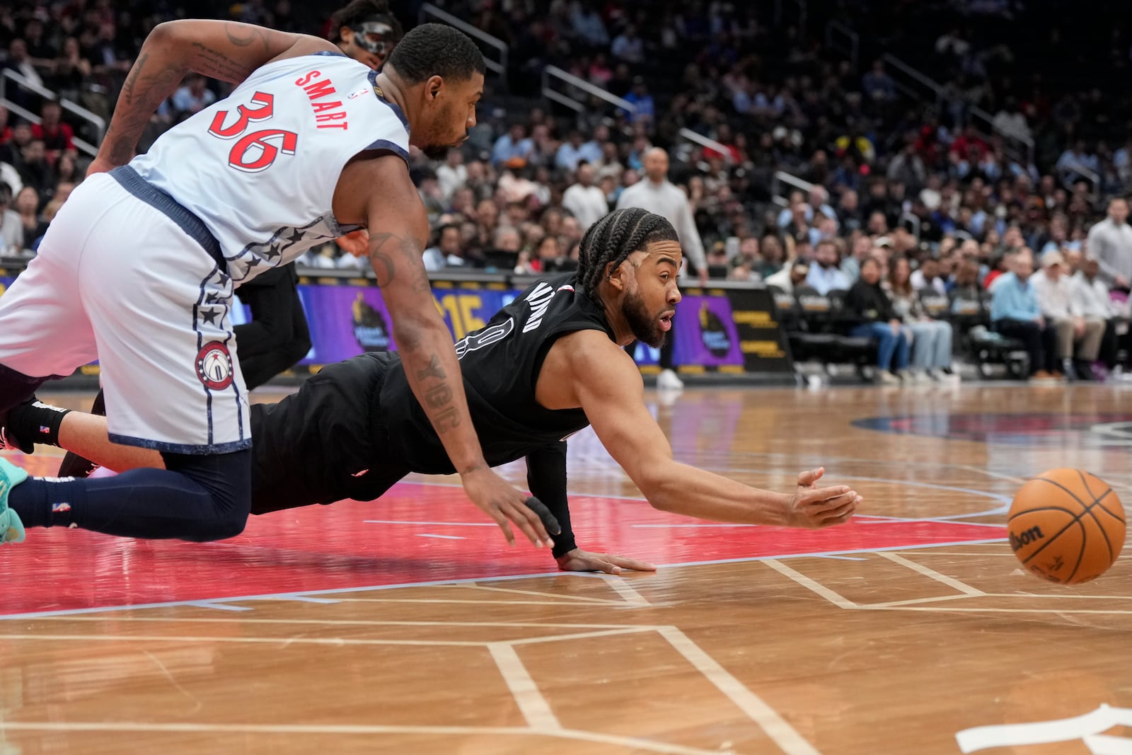 Brooklyn Nets forward Trendon Watford dives for the ball against Washington Wizards guard Marcus Smart (36) during the second half of an NBA basketball game, Monday, Feb. 24, 2025, in Washington. (AP Photo/Jess Rapfogel)